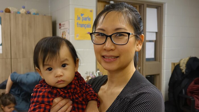 Micheline Chow tient sa fille dans ses bras,