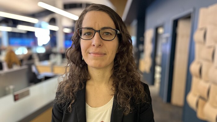 Debout dans un bureau, Michelle Landry regarde directement la caméra pour une photo.