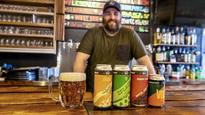 Des bières sur un comptoir avec un homme en arrière-plan.