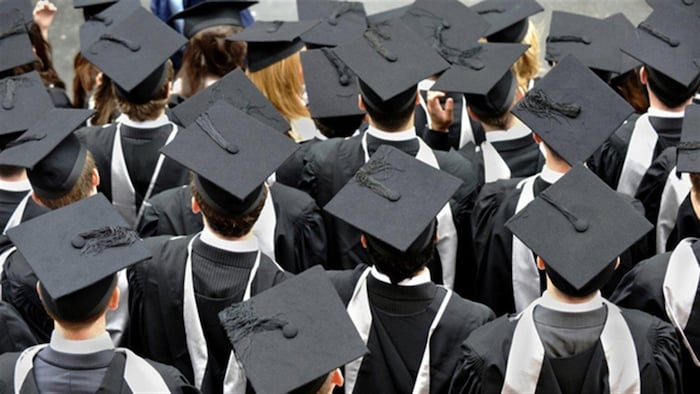 Des étudiants portant le chapeau de remise de diplôme.