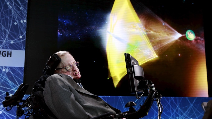 L'astrophysicien Stephen Hawking pose devant un écran géant de télévision