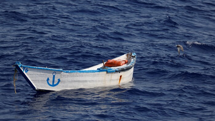 Une barque en bois au milieu de la mer.