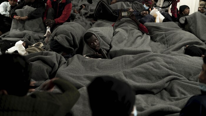 Des migrants africains allongés à l'intérieur d'un bateau de sauvetage.