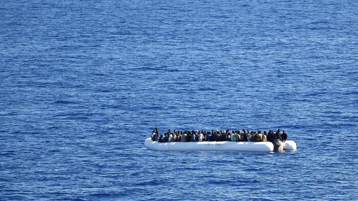 Des migrants à bord d'une embarcation en mer Méditerranée.