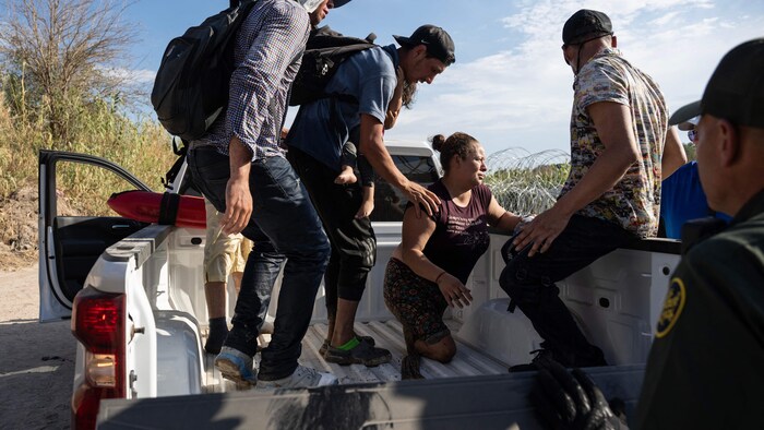 Un groupe de migrants s'installe dans une camionnette des services frontaliers.