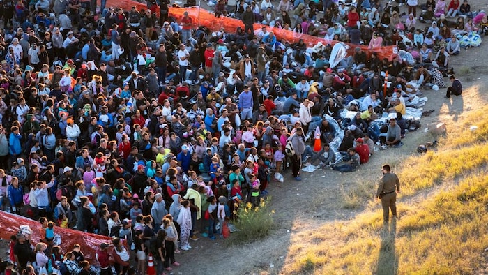 Une foule attend devant un agent.