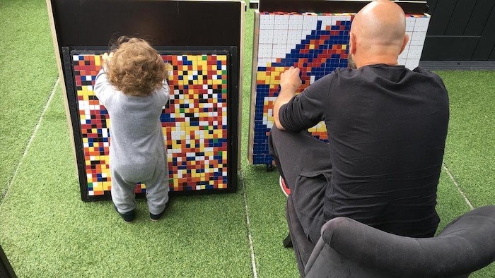 Mikael Taieb créé une œuvre d'art du pixel avec des cubes Rubik à côté de lad nouveau-né.