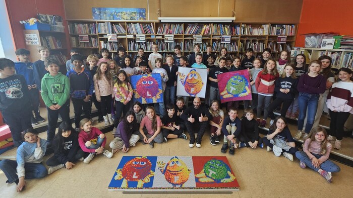 Mikael Taieb est assis dans une salle de classe avec une vingtaine d'élèves.
