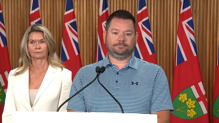 Portrait de Mike Harris en conférence de presse.