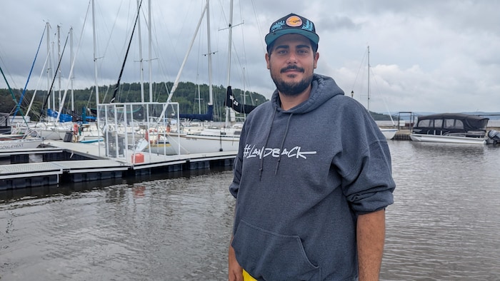 Mike Laderoute se fait prendre en photo sur le quai de bateaux. 
