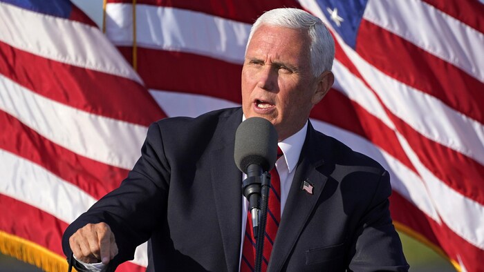 Mike Pence parle dehors devant un drapeau américain.