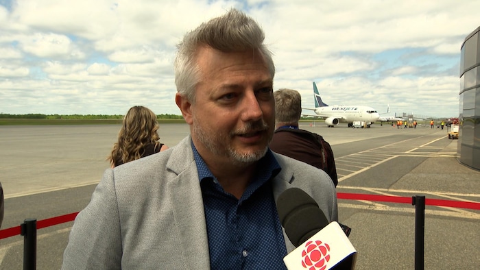 Mike Perkins, directeur principal des affaires aéroportuaires de WestJet, répond aux questions d’un journaliste. 