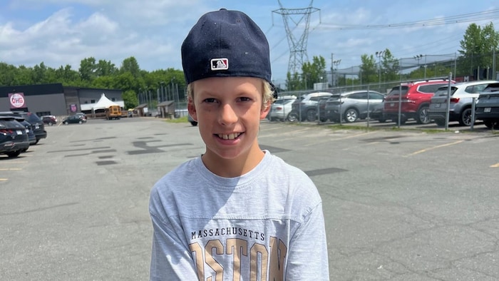 Un jeune garçon souriant à la caméra.