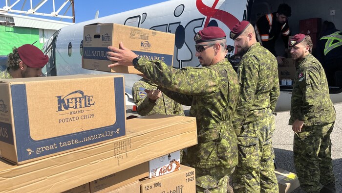 Des militaires prennent des boîtes.