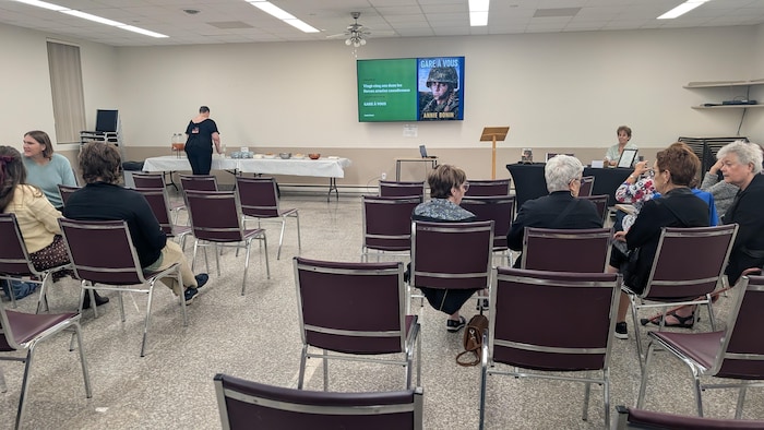 Des personnes assises sur des chaises placées en rangée.