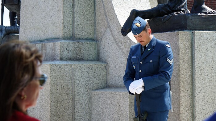 Un militaire se tient devantle Mémorial national de guerre de Terre-Neuve.