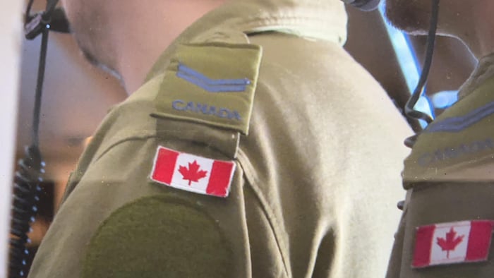 Shoulders of two unidentified Canadian soldiers.