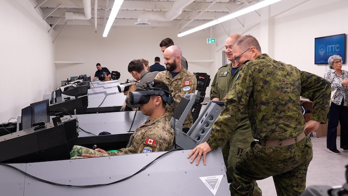 Des militaires debout autour d'une machine de simulation de vols du centre.