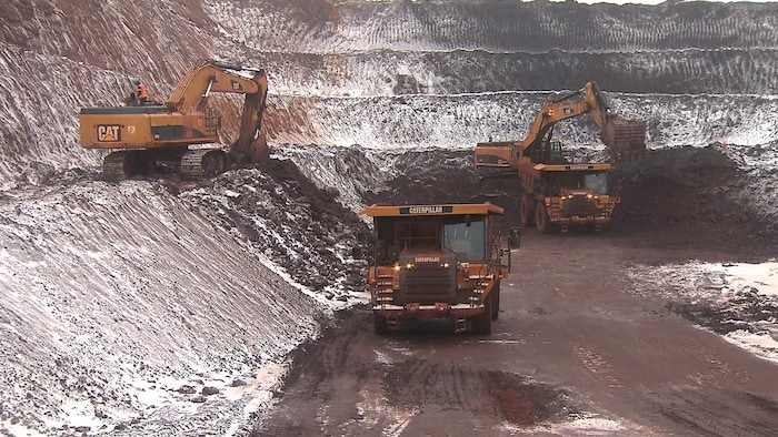Des camions travaillent dans une mine à ciel ouvert.