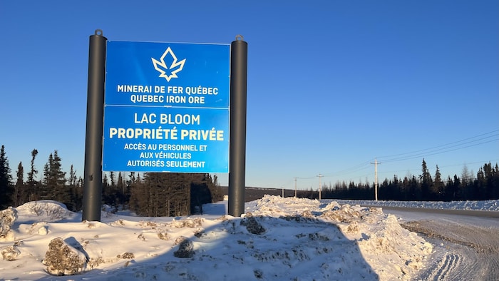 Une affiche de Minerai de fer Qubec devant une route indique qu'il s'agit d'une proprit prive.