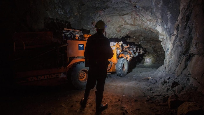 Un homme travaille avec un engin dans une mine.