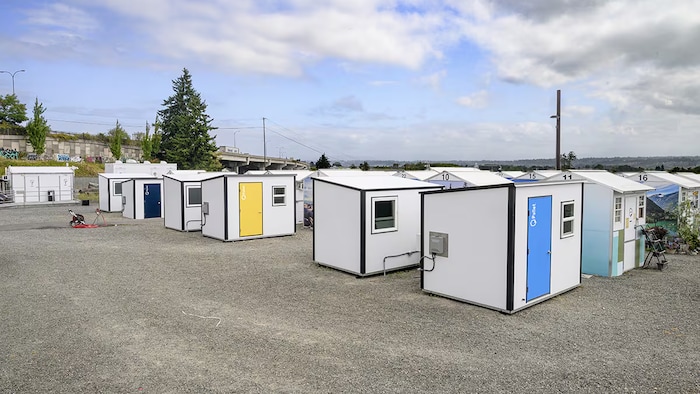 Six rangées de petites maisons individuelles disposées l'une près de l'autre sur un terrain à Kelowna.