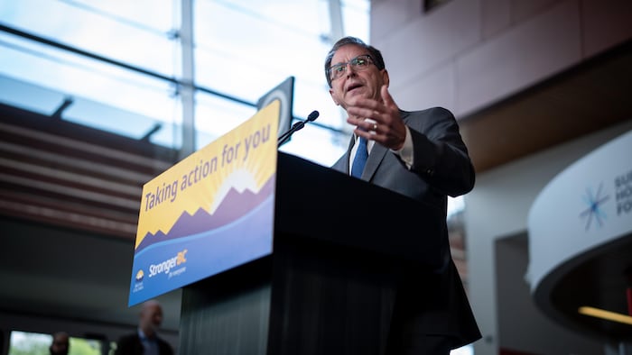 Adrian Dix devant un pupitre avec un micro.