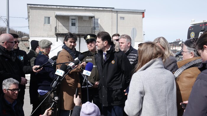 وزير السلامة العامة في كيبيك، فرانسوا بونارديل (بالزي الأسود وسط الصورة)، متحدثاً إلى وسائل الإعلام من مكان حادثة الدهس في أمكوي.