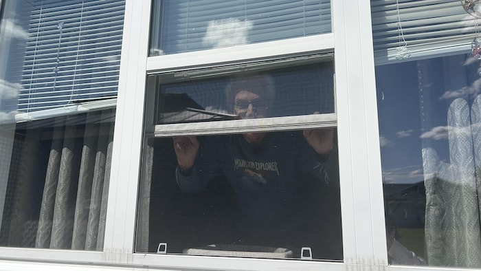 Armand Aubé ferme une fenêtre.