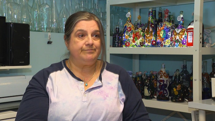 Une femme interviewée dans son studio de peinture.