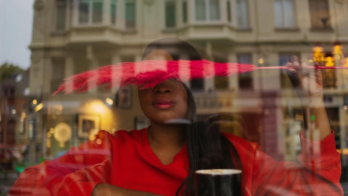 Mireille Mbayoko Yaba qui tient une plume devant ses yeux.