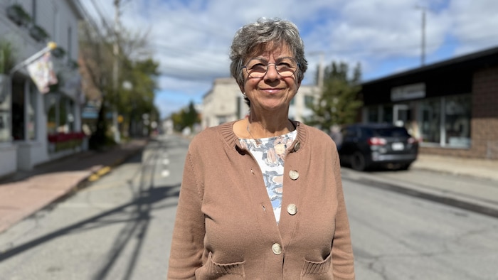 Mireille Thibault, debout, au milieu d'une rue.
