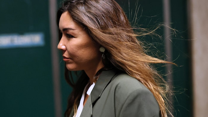 Une femme aux cheveux longs porte un veston.