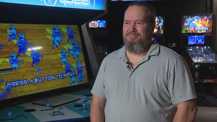 Un portrait de Mitch Rouire dans la partie arcade de son établissement.