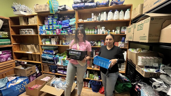 Deux femmes dans un cagibi trient et rangent des objets.