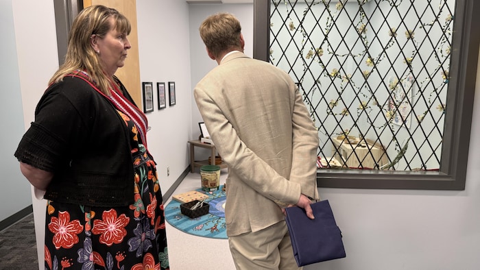 Deux personnes regardent une salle de classe.