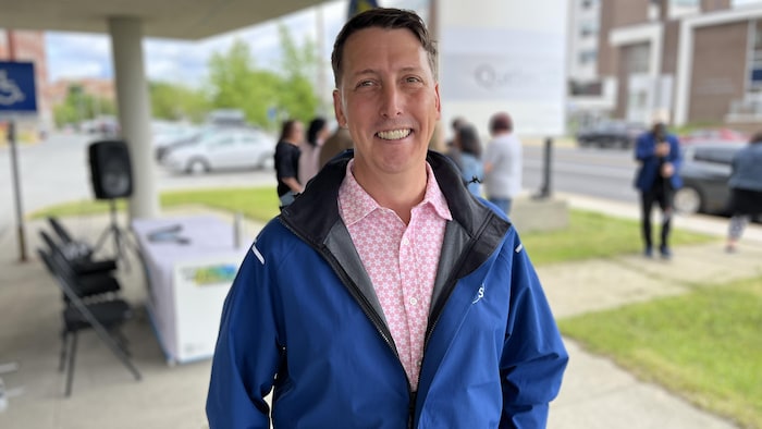 Mains dans les poches, Carl Verreault sourit pour la photo devant l'espace de mobilisation dans l'entrée de l'hôpital de Rouyn-Noranda.
