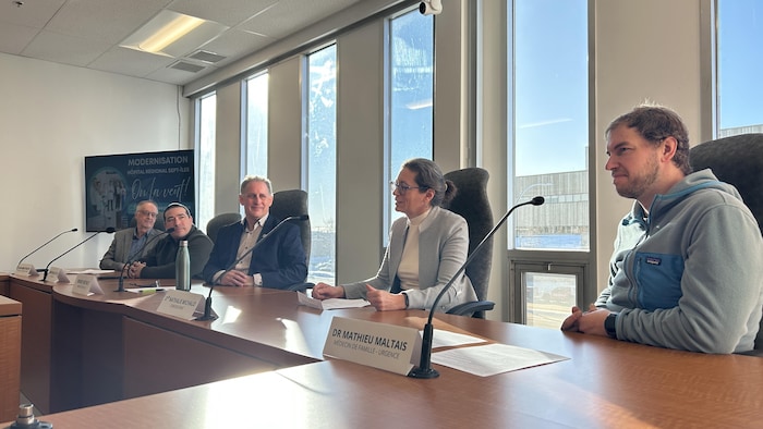 Des élus et des médecins discutent derrière des micros lors d'une conférence de presse. 