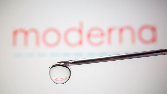 Une seringue devant le logo de Moderna.