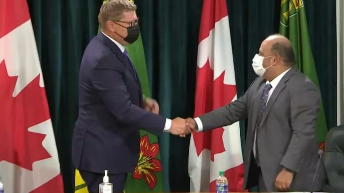 Saskatchewan Premier Scott Moe, left, and Chief Medical Health Officer Dr. Saqib Shahab, right, shake hands at the final regularly scheduled COVID-19 update on July 7, 2021.