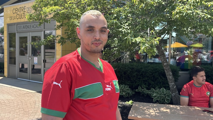 Une personne souriante porte un maillot de l'équipe de soccer du Maroc.