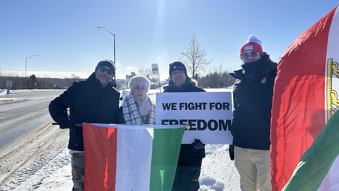 Des manifestants avec des affichent et drapeaux.