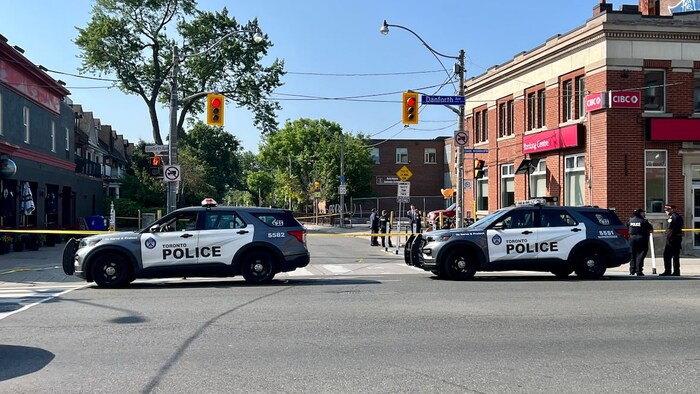 Deux voitures de police devant une scène de crime.