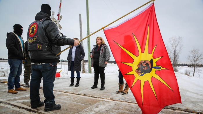 Des manifestants tiennent un drapeau mohawk.