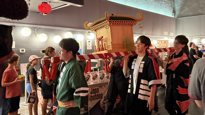 Le défilé du sanctuaire traditionnel japonais porté à l'épaule au milieu de la foule lors du festival Matsuri.
