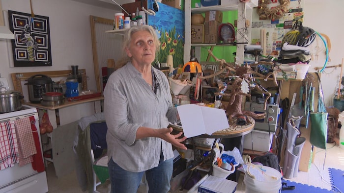 Une femme debout dans un appartement.