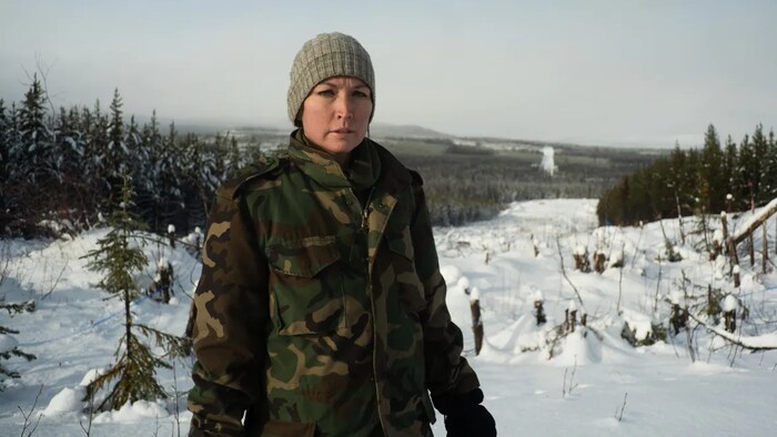 Molly Wickham au milieu d'une forêt enneigée.