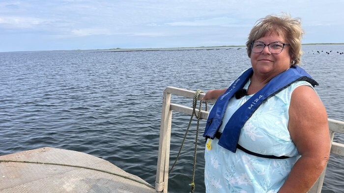 Mona Jeffery est debout sur un bateau.