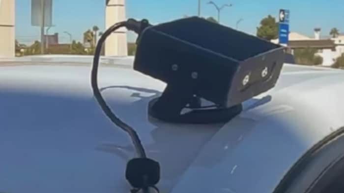 Un petit appareil électronique muni de deux caméras et installé sur le toit d'une voiture.