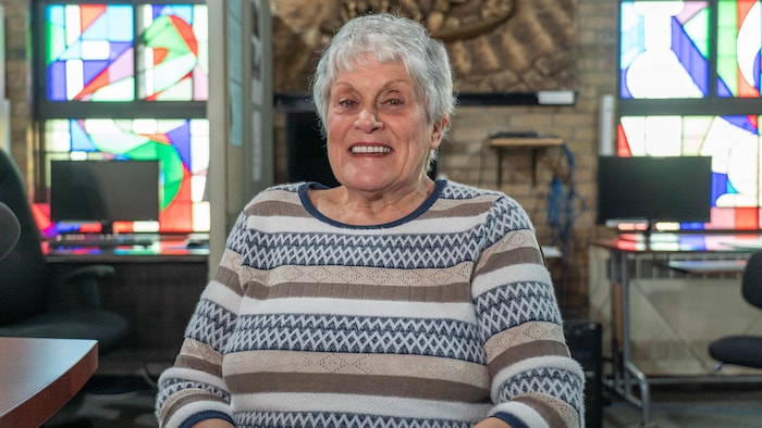 Monique Fournier, une femme âgée, regarde la caméra en souriant.
